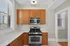 Charming kitchen with sleek stainless steel appliances, modern cabinetry, and large windows for natural light.