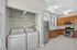 Bright kitchen featuring modern stainless steel appliances, elegant cherry wood cabinetry, and an in-unit washer and dryer for convenient living.