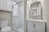 Elegant bathroom featuring a modern vanity, sleek marble countertop, and a spacious glass-enclosed shower.
