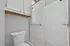 Modern bathroom featuring sleek white cabinetry, a stylish tiled shower, and an elegant toilet.
