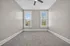Bright, spacious room with soft carpeting, neutral walls, and large windows offering a serene view.