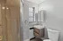 Elegant modern bathroom with a wooden-tiled shower, sleek vanity, and large window for natural light.