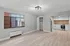 Bright and modern living space featuring sleek hardwood floors, a stylish open kitchen with stainless steel appliances, and ample natural light from large windows.