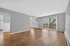 Spacious living room with elegant hardwood floors and large windows offering abundant natural light and a scenic view.