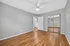 Bright and airy bedroom with elegant hardwood floors, modern ceiling fan, and mirrored closet doors.