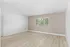 Bright and airy room featuring elegant wood flooring, neutral walls, and a large window with lush, green views.