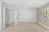 Spacious and modern empty room with elegant hardwood floors, large windows, and ample closet space, offering plentiful natural light and a serene environment.