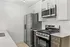 Modern kitchen with sleek stainless steel appliances, elegant white cabinetry, and quartz countertops.