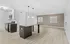 Modern open-plan kitchen and living area with elegant pendant lighting and sleek wood flooring.
