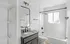 Modern bathroom featuring sleek black fixtures, a spacious vanity, and bright natural lighting from the window.