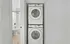 Modern apartment featuring a stacked in-unit washer and dryer next to a pristine bathroom, highlighting convenience and efficiency.
