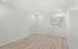 Bright and spacious room with modern wood flooring and large window, offering ample natural light.
