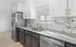 Elegant kitchen with modern stainless steel appliances, marble backsplash, and abundant natural light.