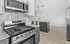 Modern kitchen with sleek stainless-steel appliances, elegant marble backsplash, and spacious island with pendant lighting.