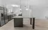 Modern kitchen with sleek stainless steel appliances, elegant marble backsplash, and stylish pendant lighting over a spacious island.
