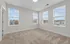 Bright and spacious carpeted room with large windows offering beautiful city views, perfect for a cozy bedroom or home office.