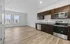 Bright and airy open-concept kitchen with sleek stainless steel appliances, modern cabinetry, and expansive hardwood flooring, perfect for contemporary living.