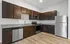 Modern kitchen with elegant dark wood cabinetry, sleek stainless steel appliances, and granite countertops.