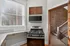 Charming kitchen nook with sleek stainless steel appliances, large bright window, and rustic brick accent walls. Clermont Condominiums