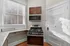 Contemporary kitchen with sleek stainless steel appliances and large bright windows for natural light. Clermont Condominiums