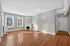 Inviting living room with elegant hardwood flooring, large windows, and a charming fireplace, offering ample natural light. Apartments in East Walnut Hills, Clermont Condominiums