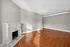 Elegant living room with warm hardwood floors and a classic white fireplace, offering a cozy and inviting atmosphere. Clermont Condominiums apartments in East Walnut Hills.