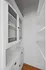 Bright, modern pantry featuring sleek white cabinetry with glass doors, perfect for stylish and organized storage solutions. Clermont Condominiums apartments in East Walnut Hills.