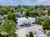 Aerial view of a charming apartment complex surrounded by lush greenery and a quaint residential neighborhood, offering serene living with ample parking. Flats at Wasson Way Hyde Park Apartments Building Exterior
