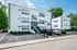 Charming white brick apartment complex with landscaped entrance and convenient parking, bathed in natural light. Flats at Wasson Way Hyde Park Apartments | Exterior