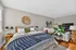 Cozy and stylish bedroom with a large bed, modern decor, natural light, and a relaxing sitting area.