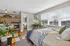 Bright, modern studio apartment featuring a cozy sleeping area, sleek kitchenette, chic workspace, and abundant natural light from large windows.