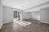 Bright and inviting room with wood flooring, a ceiling fan, and large sliding glass doors leading to a garden patio.