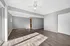 Spacious open-concept living area with elegant hardwood floors, modern ceiling fan, and abundant natural light.