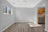 Bright and inviting dining area with wood flooring and large window, adjacent to a modern kitchen with stainless steel appliances and sleek cabinetry.
