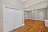 Spacious apartment interior featuring elegant hardwood flooring, modern recessed lighting, and classic double-door closet.