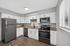 Modern kitchen with sleek stainless steel appliances, granite countertops, and large window for natural light.