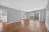 Spacious living area with elegant hardwood floors and large sliding glass doors leading to a scenic balcony view.