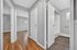Charming apartment interior featuring a hallway with elegant hardwood floors leading to bright rooms and a modern bathroom.