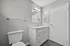 Modern bathroom design featuring elegant vanity with sleek countertop, stylish light fixture, and spacious layout.