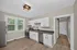 Bright kitchen with modern stainless steel appliances, white cabinetry, and elegant wood flooring.