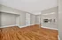 Elegant and spacious open-plan living area featuring sleek hardwood floors, modern kitchen pass-through, and soft neutral walls.