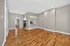 Modern open-concept apartment with gleaming hardwood floors and a sleek kitchen, perfect for stylish living.
