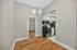 Modern apartment kitchen and dining area with sleek stainless steel appliances, elegant cabinetry, and polished hardwood floors.