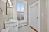 Bright bathroom with elegant marble vanity, modern fixtures, and natural light streaming through a large window.