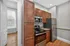 Modern kitchen with sleek stainless steel appliances, warm wood cabinetry, and granite countertops, offering a stylish and functional space.