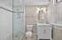 Elegant bathroom with a sleek glass shower, modern vanity, and large window offering natural light.