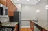 Modern kitchen with granite countertops, sleek stainless steel appliances, and elegant wooden cabinetry.