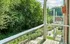 Charming balcony view with lush greenery, modern railing, and cozy atmosphere.