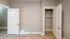 Inviting room with a spacious open closet and elegant wooden floors.