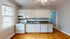 Inviting kitchen with white cabinets, sleek countertops, and modern appliances including a stove and microwave.